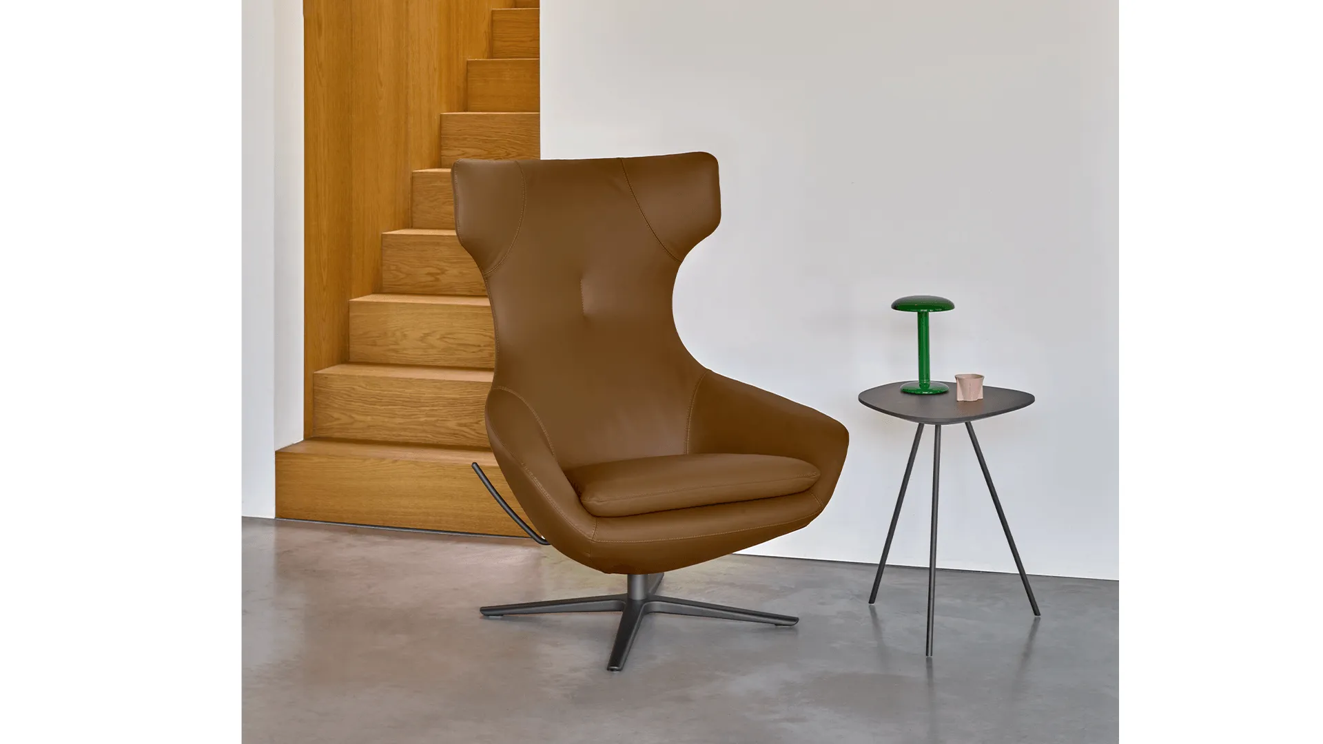 Leolux fauteuil naast een houten trap